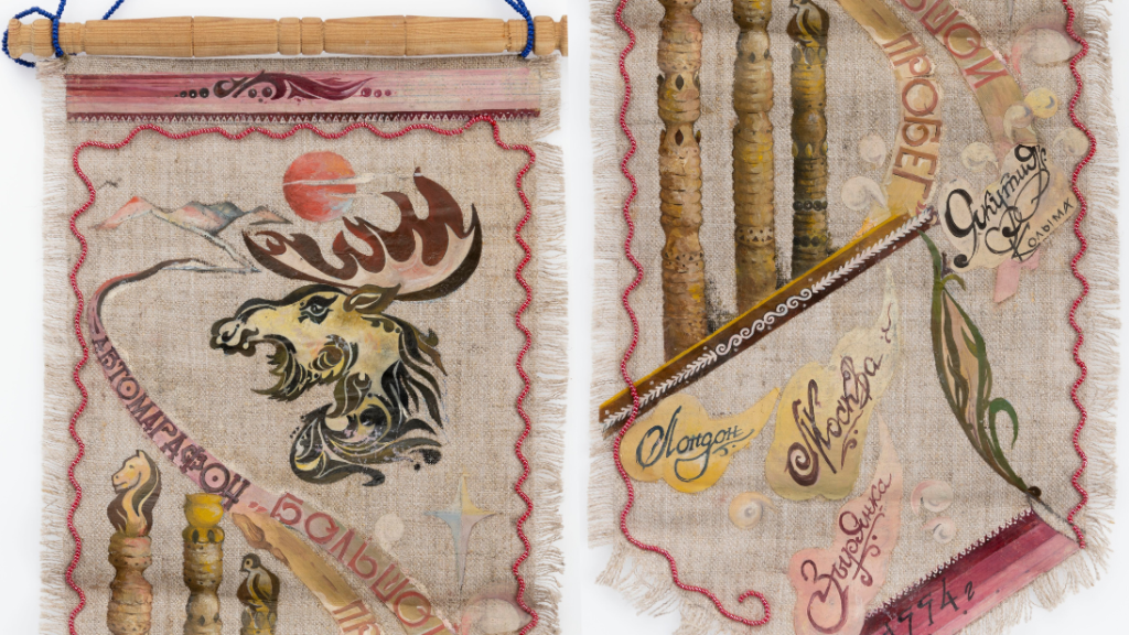 A wall hanging featuring painting and beading. The artwork is intricate, with painting and beading. There are words painted on, along with artworks of nature, including the moon, a moose head, and foliage.