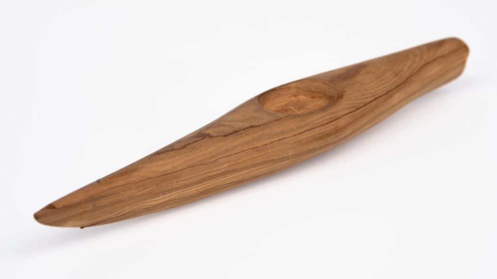 A carved wooden kayak in a very simple style. 