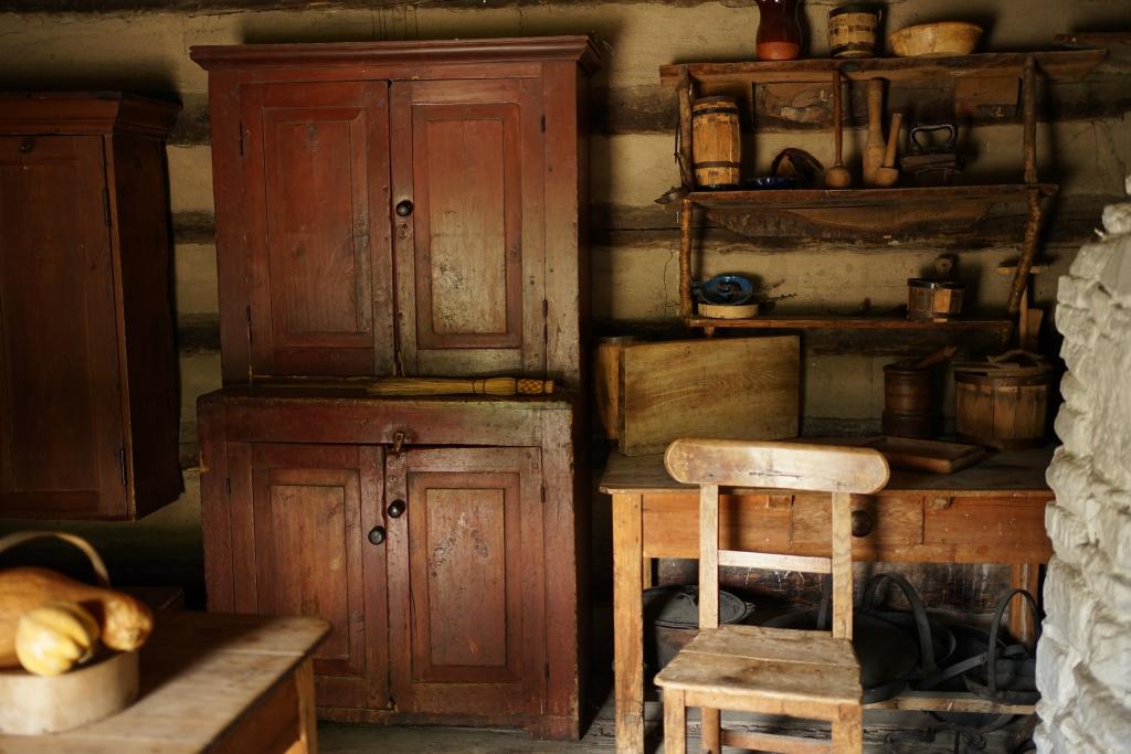 The interior of a log cabin, staged as it might have looked in the 1800s.