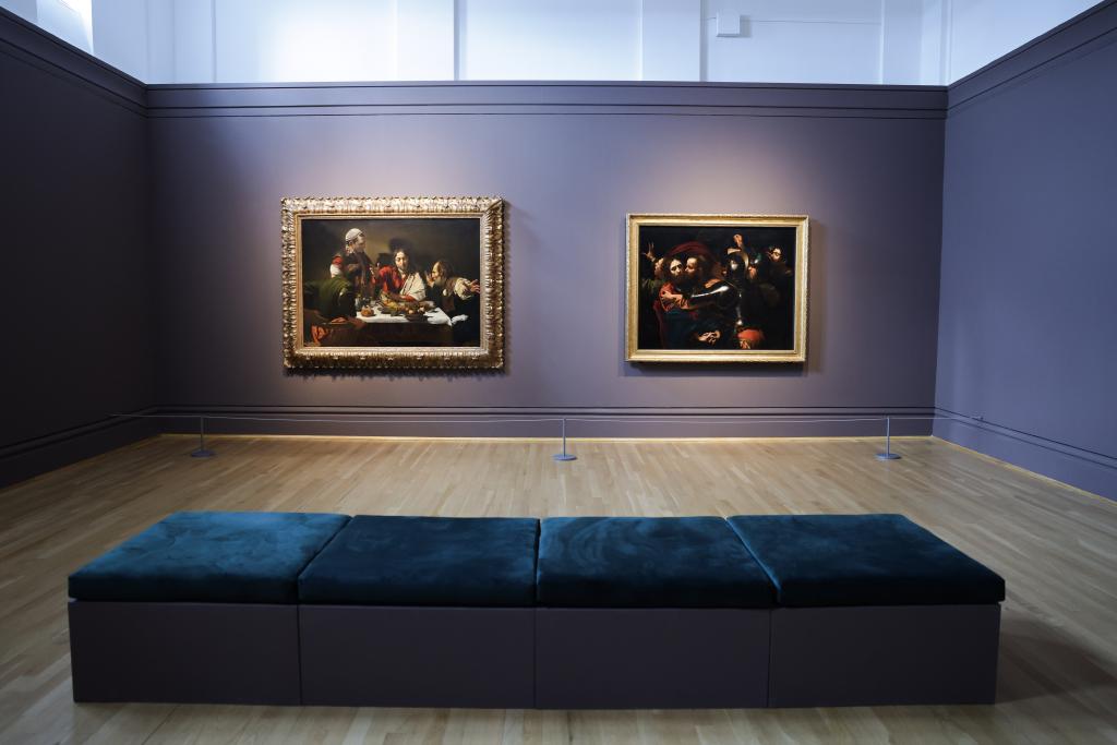 UM - Caravaggio Exhibition two paintings with a blue sofa in front of them