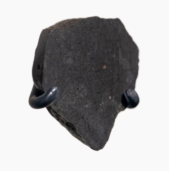 A small lunar meteorite, triangular in shape.