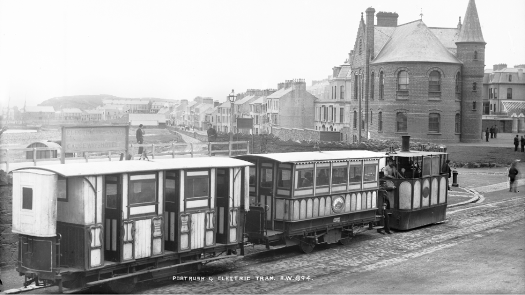 A black and white photograph from the 1900s showing a tram leaving Portrush.