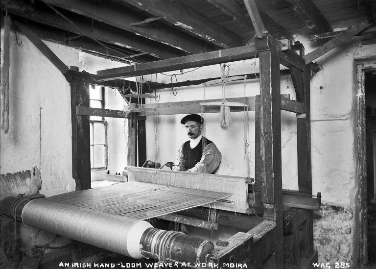 Interior of house showing man operating the loom