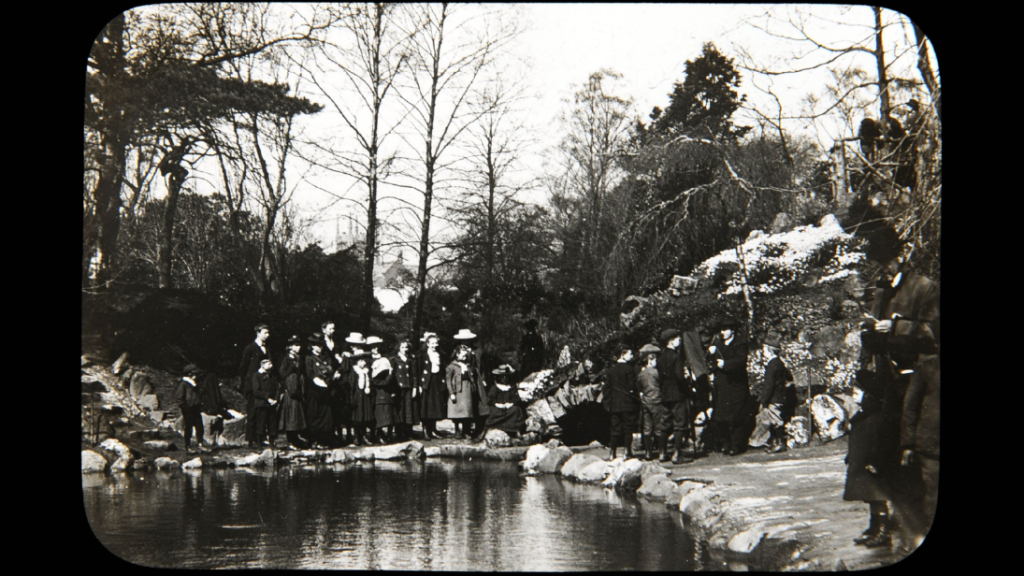 Group of girls and boys gathered at pond in Botanic Gardens