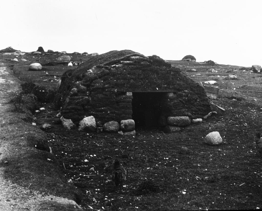 A photograph from the early 1900s showing a hut made from sod.