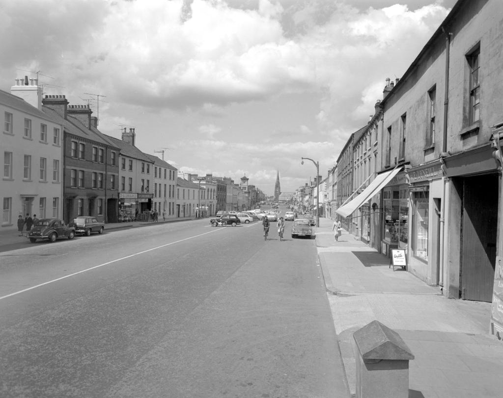 A black and white image of a town and a wide road.