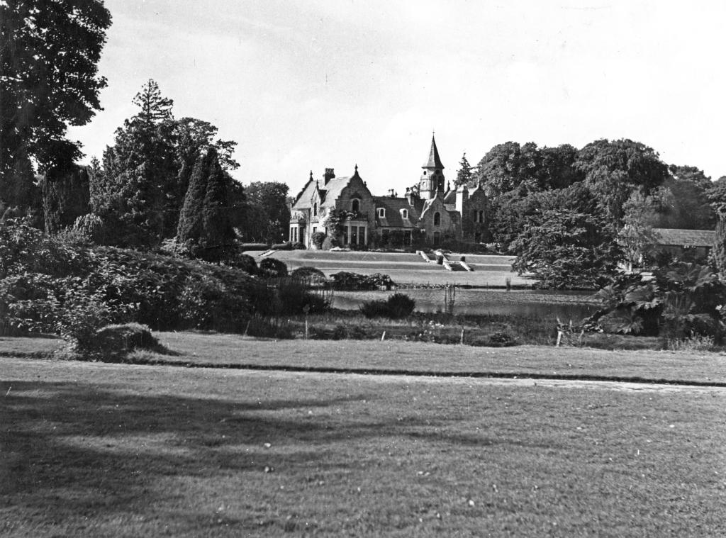 A black and white photograph of Tempo Mano, a small but grand house sitting on a large estate.