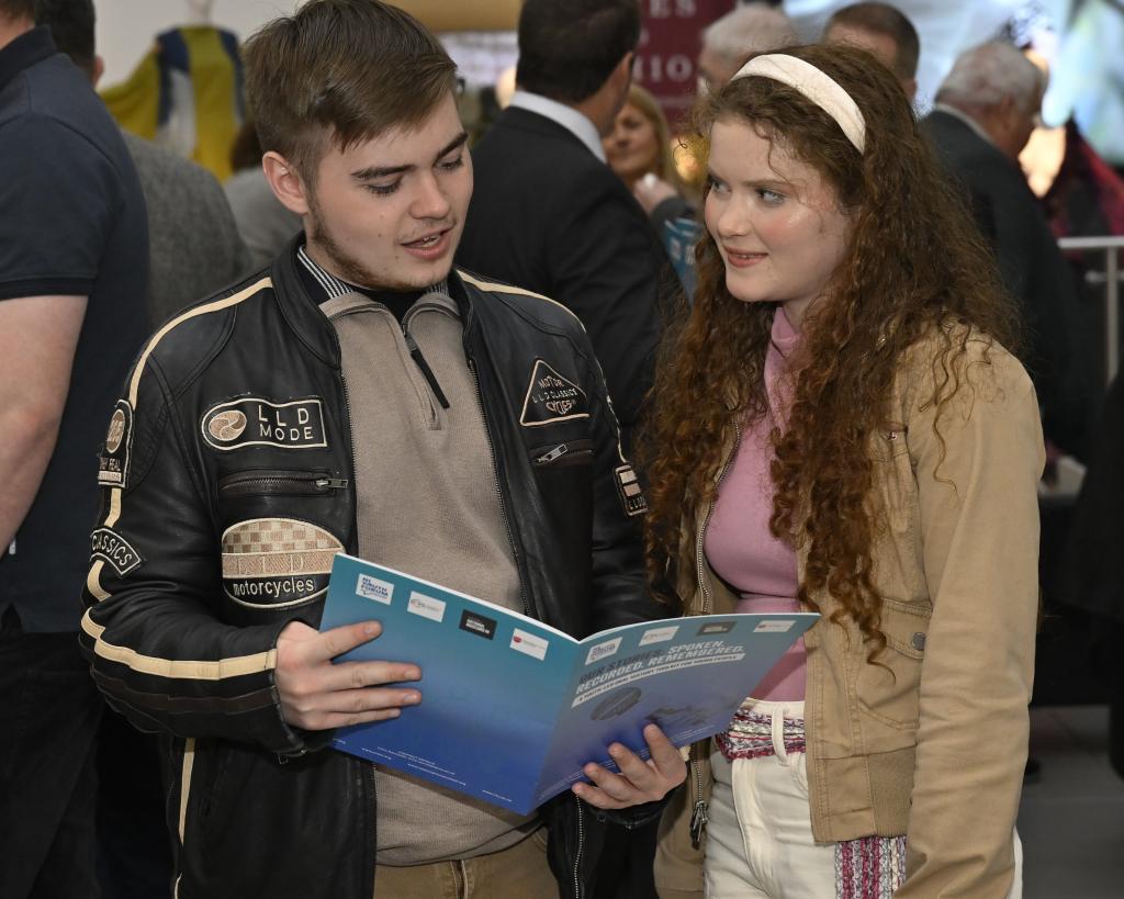 Young people looking at the oral history toolkit booklet.